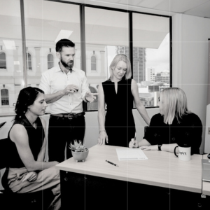 Trekk Advisory business advisory team collaborating on strategy around a shared desk in a modern city office.