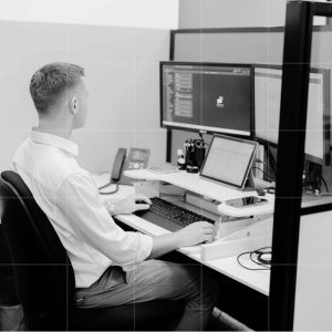 A Trekk Advisory team member seated at a multi-monitor computer setup in the office.