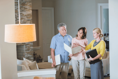 Real estate agent showing new investment property to pensioners
