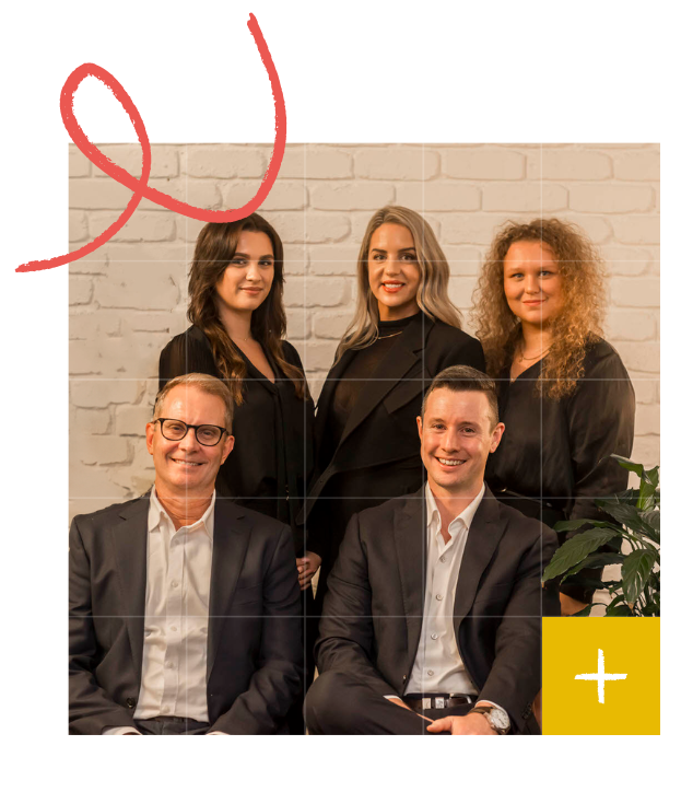 A group photo: 4 women and 2 men, posed by a white brick wall. Men sit in front, women stand behind, all in accountant business attire.