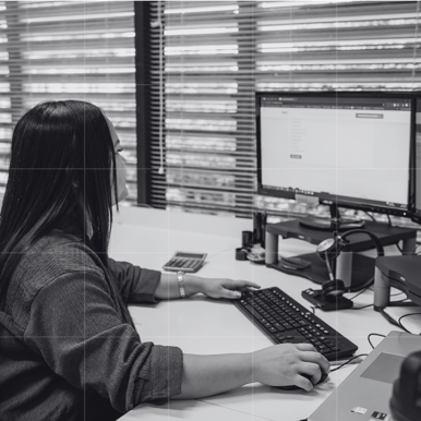 Business accountant working at a desk, analysing financial data on a computer to develop a strategic business and cashflow plan for clients.