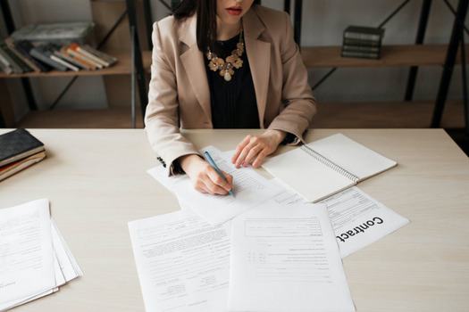 A female employer reviewing contracts as annualised wage arrangement changes.