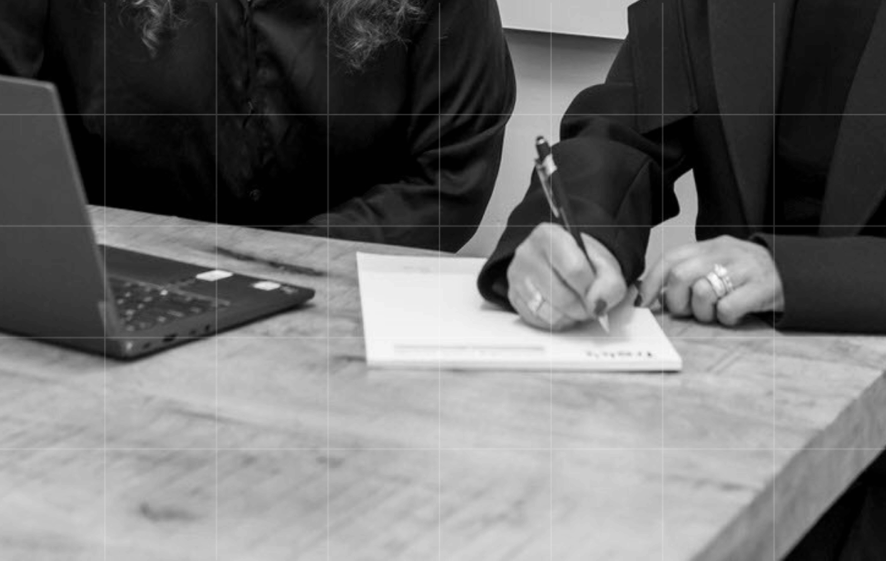 A Trekk Advisory team member signing a document at a desk.