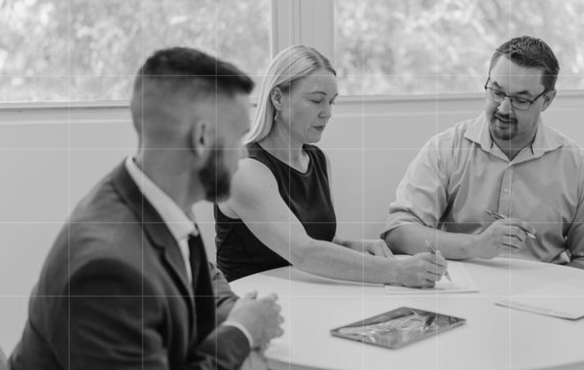 Trekk Advisory team members working through documents together around a meeting table during a business advisory session
