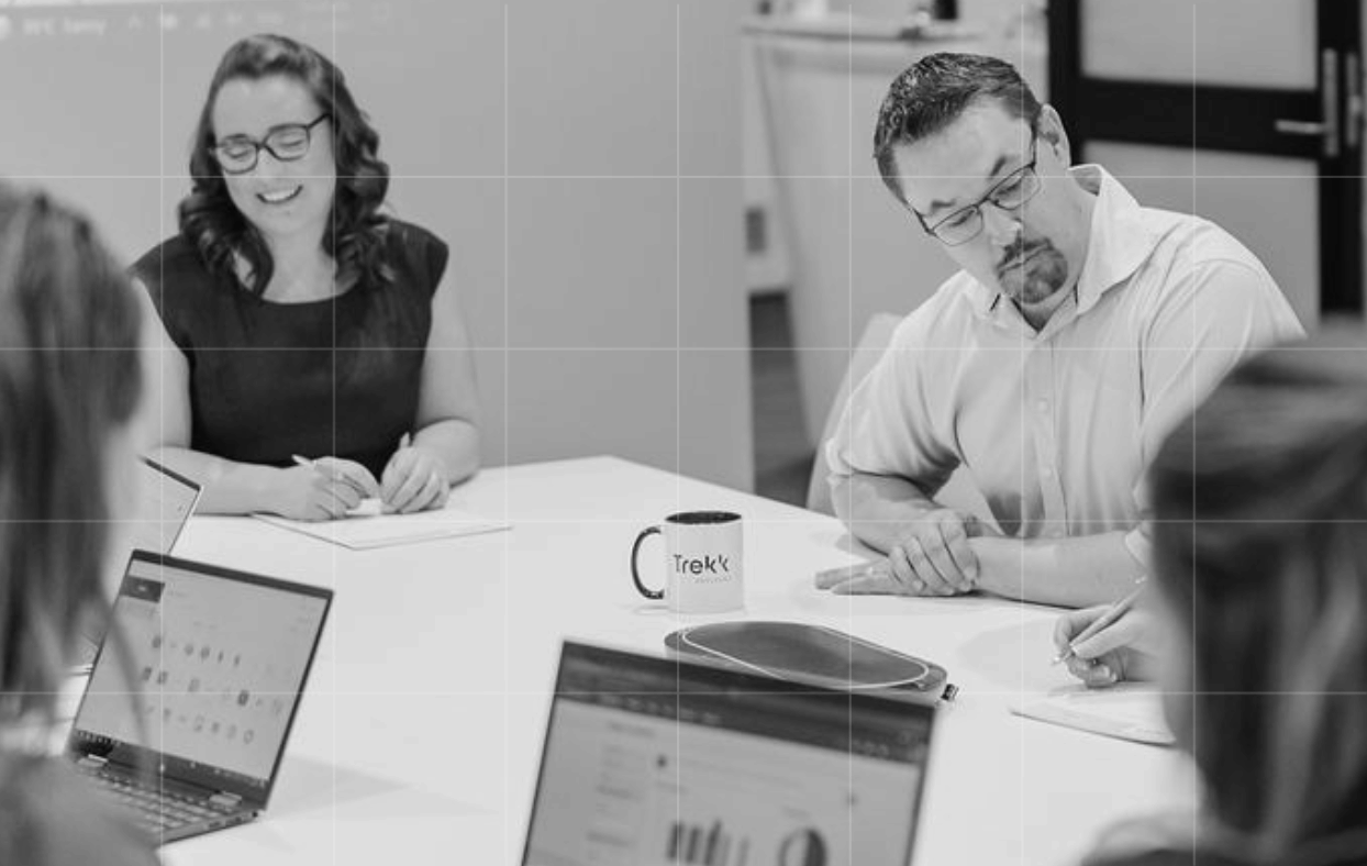 Trekk Advisory team members reviewing documents together at a desk.