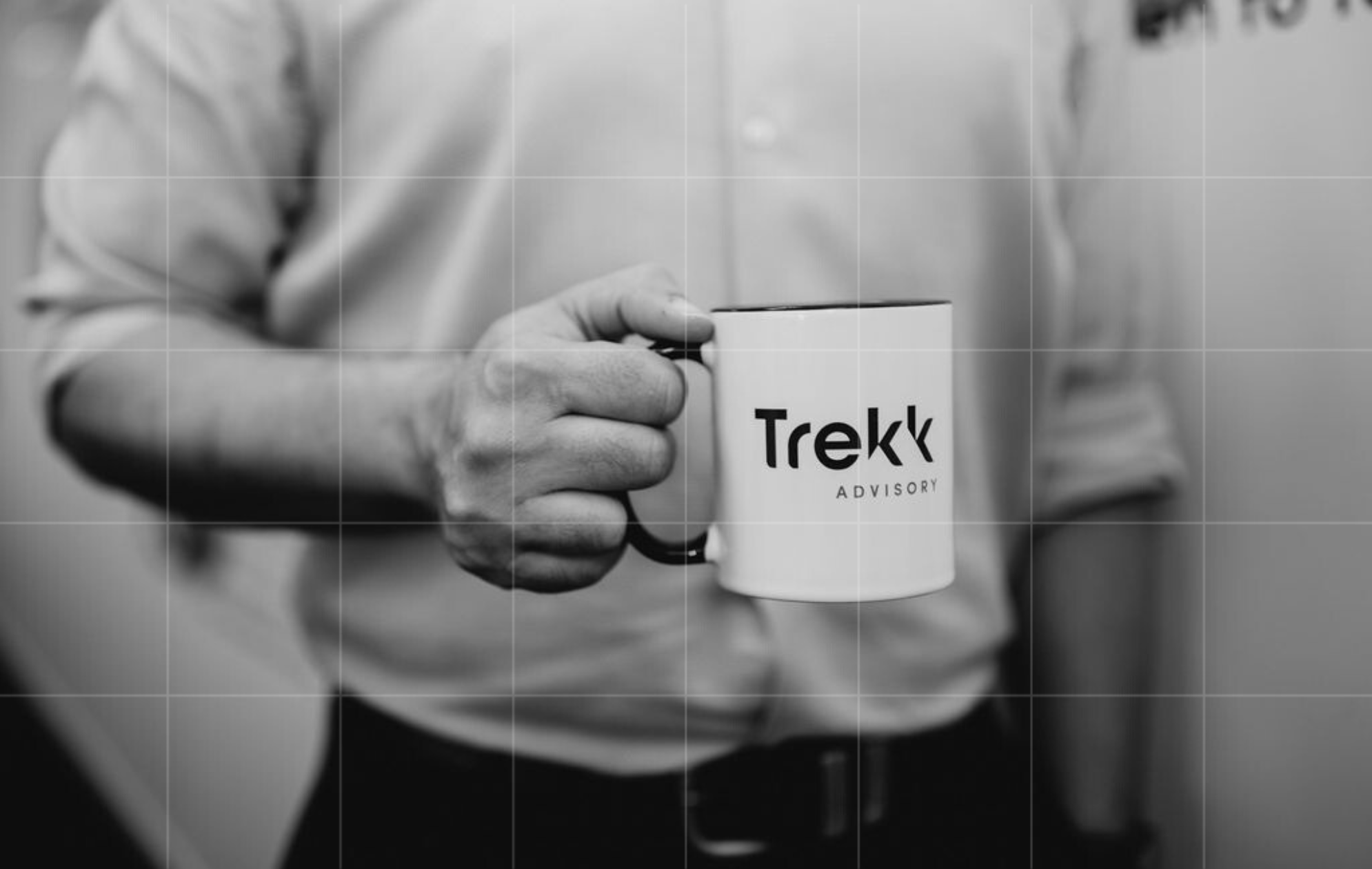 Close-up of a Trekk Advisory branded coffee mug held by a team member, symbolising approachable expertise and trusted business support.