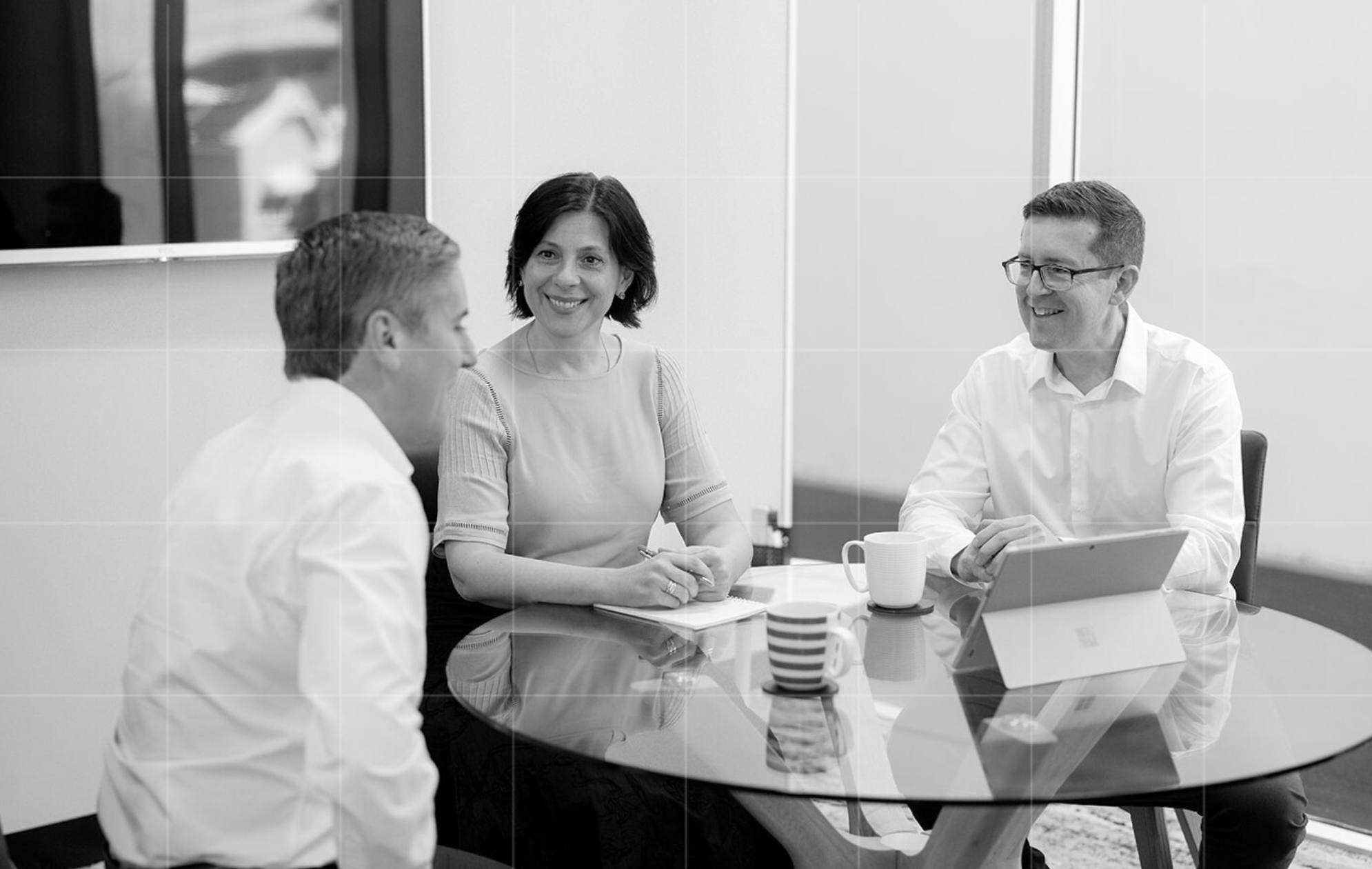 A candid moment of a business advisor consulting with a colleague at their desk. Trekk Advisory’s expert tax consultants offer professional guidance in a collaborative workspace.